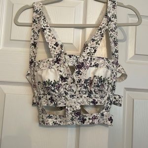 Flattering floral cut out crop top. Adjustable straps and side stretch. Zips up.